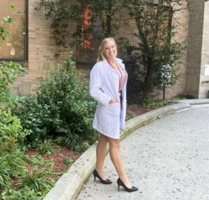 Young female doctor standing in front of hospital